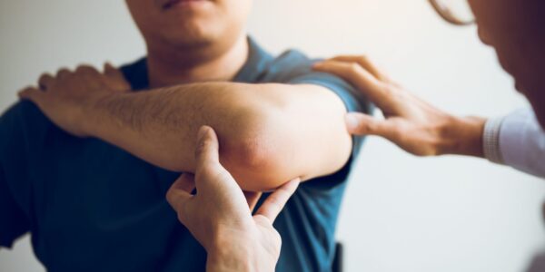 Physical therapists are checking patients elbows at the clinic office room.